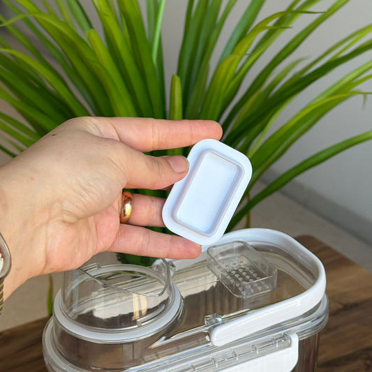 سندوقی خۆراکی هەڵگرتن لەگەڵ کوپێکی پێوانە