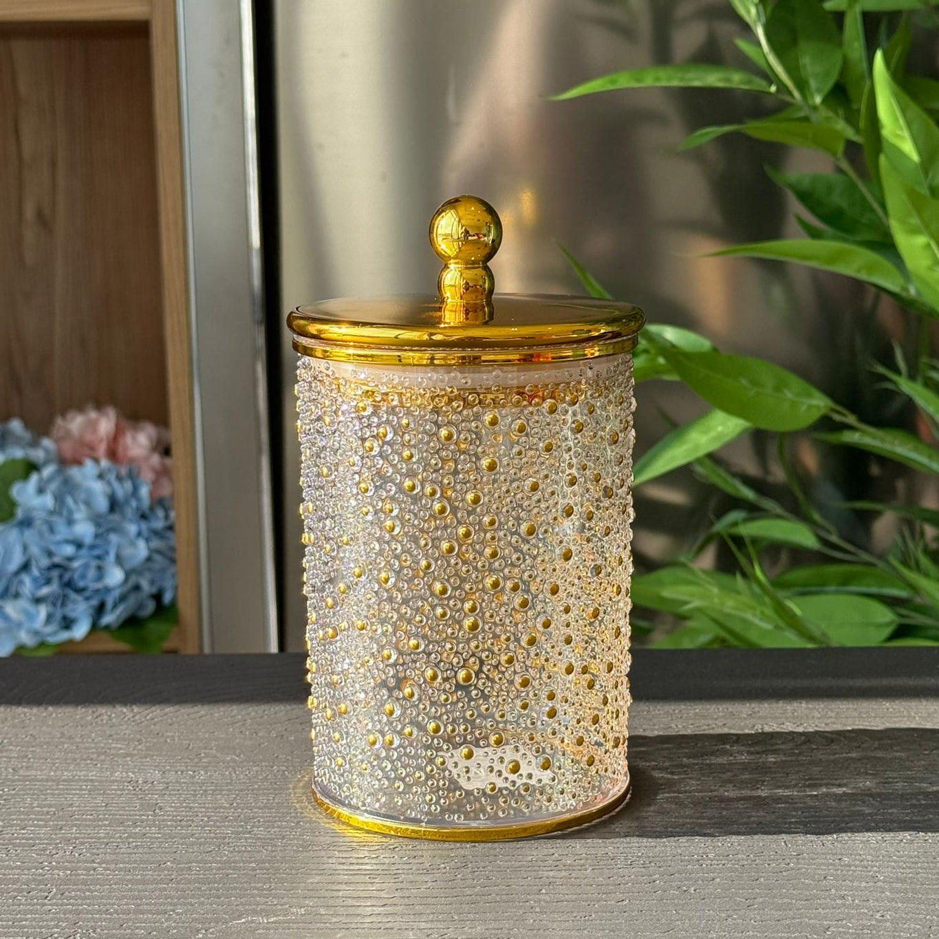 قاپێکی کەرەستەی ڕازاوەی لوکس بە سەرپۆشێکی زێڕین