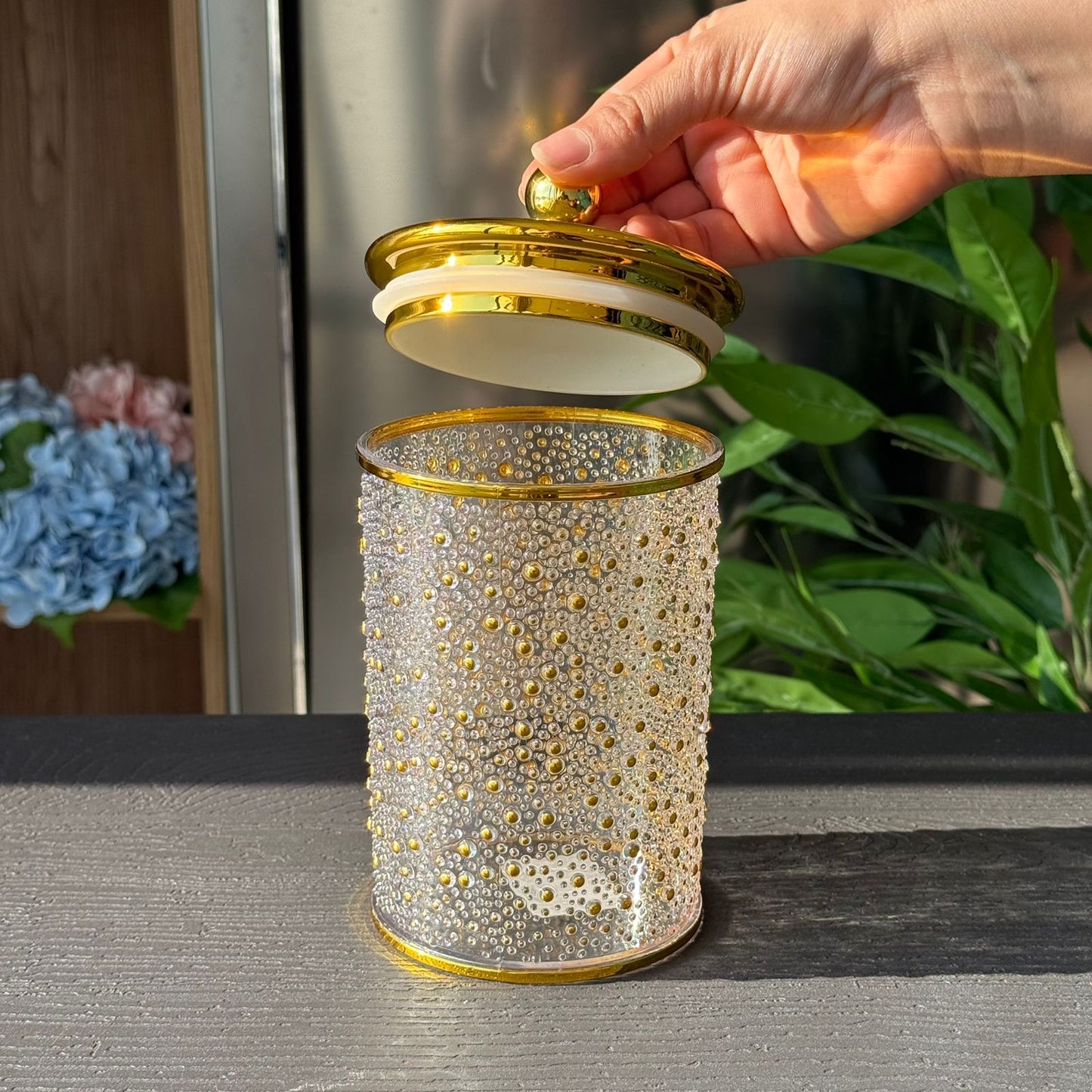 قاپێکی کەرەستەی ڕازاوەی لوکس بە سەرپۆشێکی زێڕین